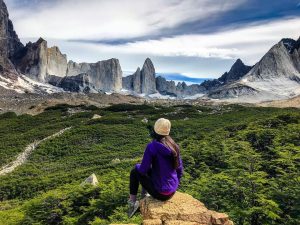 Viajera observando paisaje con bosque y montañas